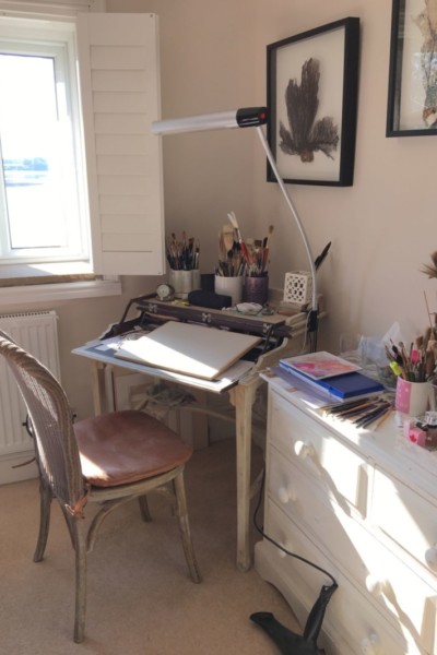 Great use of the light here  by using a desk with a sliding tray beside a window.